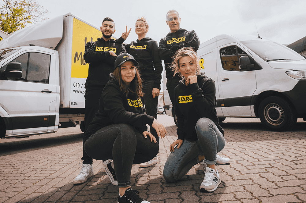Team von STARCAR-Mitarbeitern vor einem weißen Transporter.