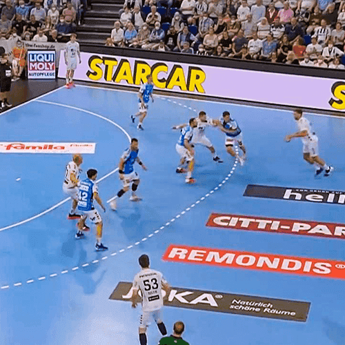 Handballspiel mit 'Starcar'-Banner am Spielfeldrand.
