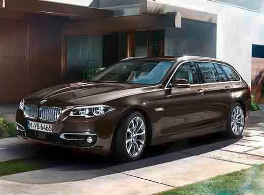 Dunkelbrauner 5er BMW Mietwagen auf einer Auffahrt geparkt.