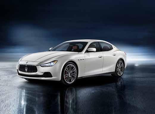 Weißer Maserati Ghibli Sportwagen auf reflektierender Oberfläche.