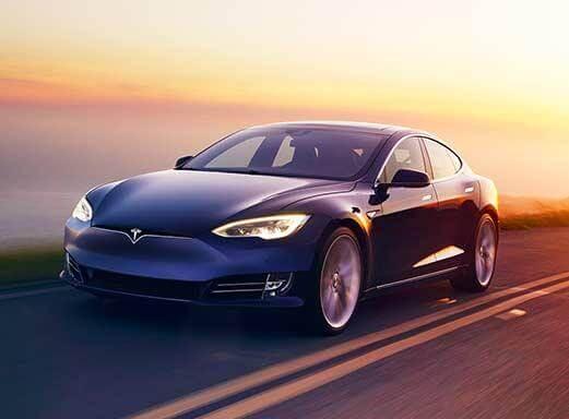 Blaues Tesla Model S Elektroauto fährt auf einer Straße.