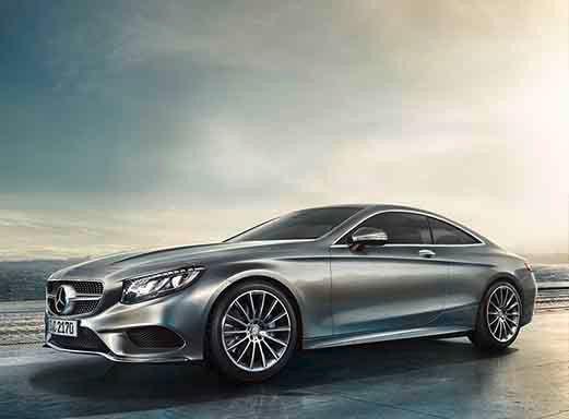 Silbernes Mercedes Benz S500 Coupe, Seitenansicht, geparkt auf einem Bürgersteig.