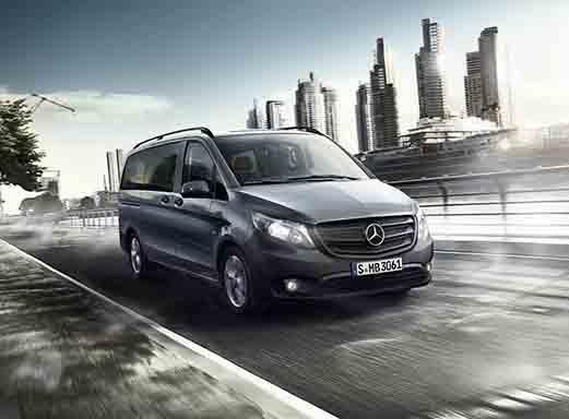 Grauer Mercedes-Benz Vito 9-Sitzer Transporter fährt schnell auf einer Straße.