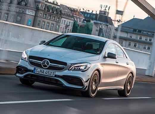 Silberner Mercedes CLA AMG fährt auf einer Brücke.