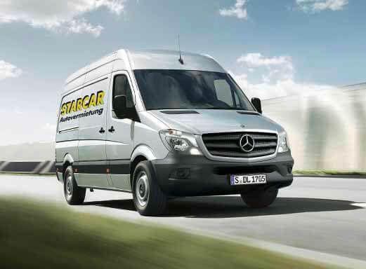 Silberner Mercedes Benz Vito Transporter mit Starcar Logo auf der Straße.