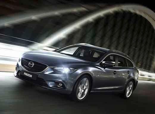 Silberner Mazda 6 fährt über eine beleuchtete Brücke.