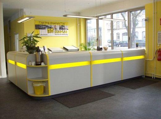 Innenansicht einer STARCAR Autovermietungsstation mit grau-gelbem Service-Schalter.