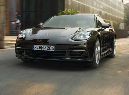 STARCAR Porsche in Köln, ein schlankes schwarzes Sportauto auf einer Stadtstraße.
