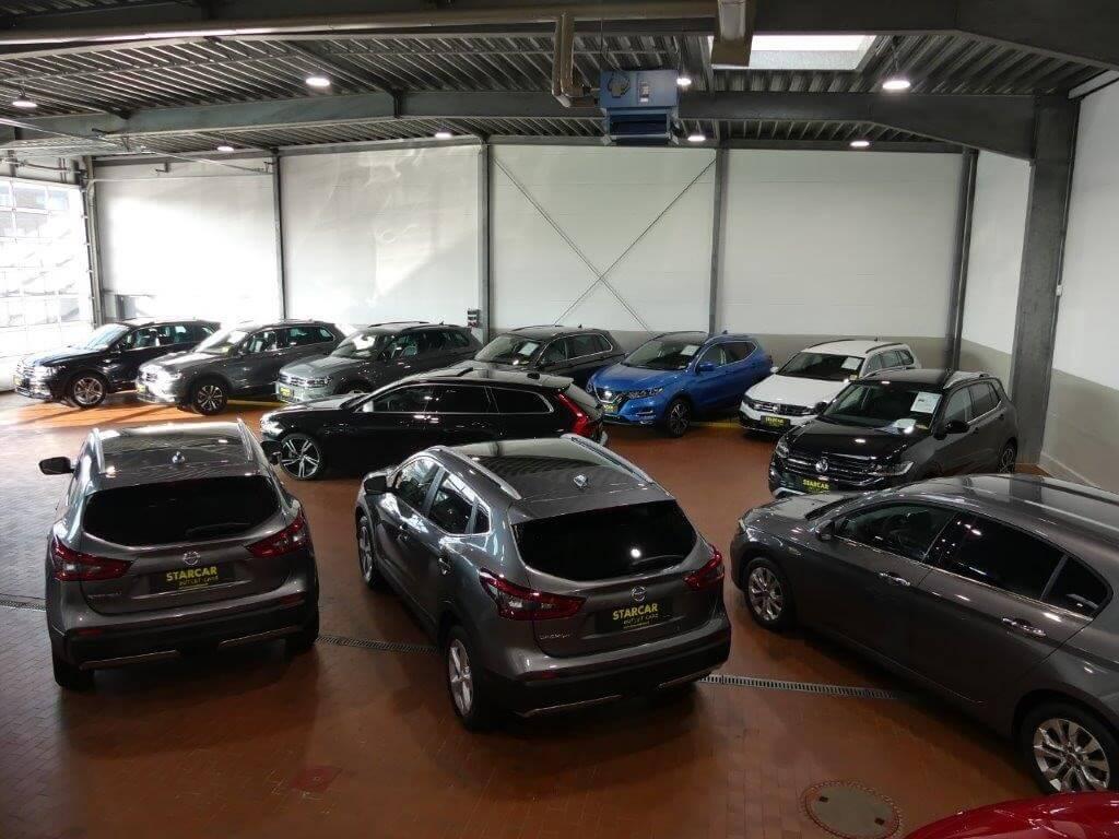STARCAR Outlet Cars Gebrauchtwagen: Viele gebrauchte Autos werden in einer Halle ausgestellt.